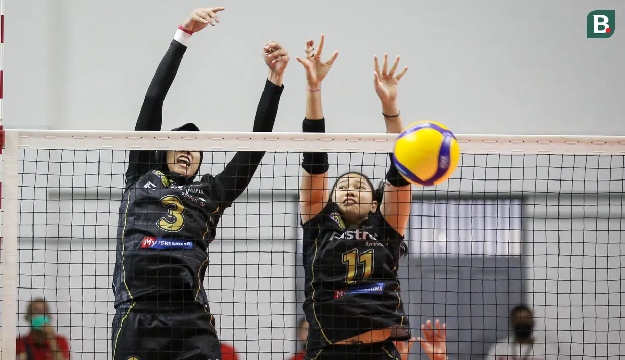 Pemain Jakarta Pertamina Fastron, Megawati Hangestri Pertiwi (kiri) dan Myrasuci Indriani berusaha menahan bola saat leg kedua final four PLN Mobile Proliga 2022 melawan Gresik Petrokimia Pupuk Indonesia di Padepokan Voli Jenderal Polisi Kunarto, Jumat (18/03/2022). (Bola.com/Bagaskara Lazuardi)