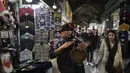Seorang musisi jalanan memainkan musik di grand bazaar bersejarah tua Teheran, Iran, Minggu (26/2/2023). Nilai tukar mata uang Iran, Rial, mencapai 600.000 per 1 dollar AS pada Minggu yang merupakan rekor terendah akibat krisis ekonomi berkepanjangan. (AP Photo/Vahid Salemi)