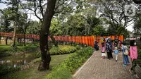 Pengunjung berjalan di Tebet Eco Park, Jakarta, Selasa (10/5/2022). Warga memanfaatkan libur dengan bermain dan berolahraga di taman terbuka setelah pemerintah memperpanjang masa liburan sekolah hingga tanggal 11 Mei 2022. (Liputan6.com/Faizal Fanani)