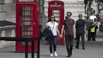 Orang-orang berjalan melewati bilik telepon umum di pusat Kota London, Inggris (8/9/2020). Angka resmi terbaru Inggris pada Selasa (8/9) menunjukkan bahwa korban meninggal akibat COVID-19 di negara tersebut telah mencapai 57.400. (Xinhua/Han Yan)