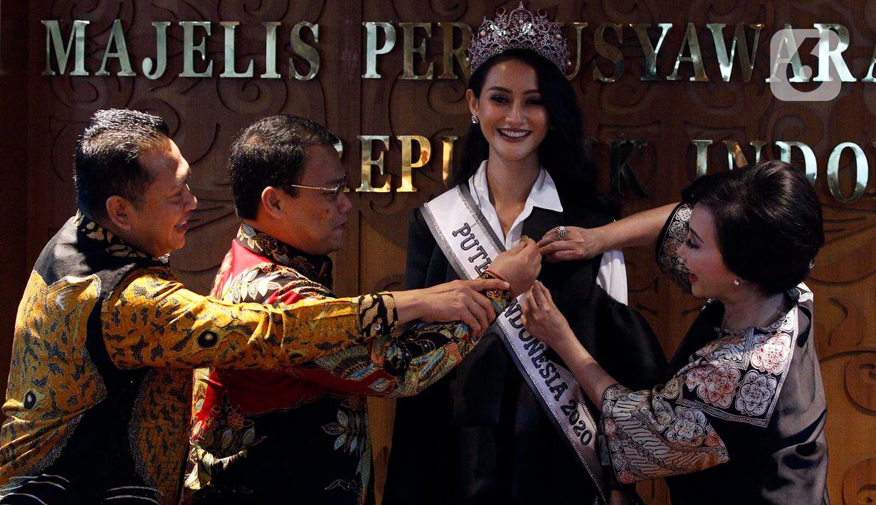 Wakil Ketua MPR Ahmad Basarah (kedua kiri) menyematkan pin kepada Puteri Indonesia 2020 Ayu Maulida di Kompleks Parlemen, Senayan, Jakarta, Kamis (12/3/2020). Puteri Indonesia 2020 Ayu Maulida dan sejumlah runner up didaulat menjadi Duta MPR RI. (Liputan6.com/Johan Tallo)