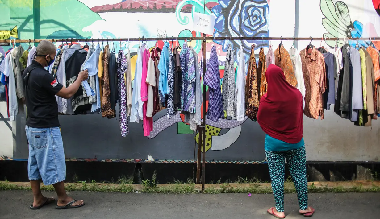 Warga memilih pakaian bekas layak pakai hasil sumbangan di RT 02 RW 04, Kelurahan Jati Padang, Jakarta, Jumat (22/5/2020). Pakaian bekas layak pakai serta sayur mayur disediakan bagi warga terdampak Pembatasan Sosial Berskala Besar (PSBB) untuk pencegahan COVID-19. (Liputan6.com/Faizal Fanani)