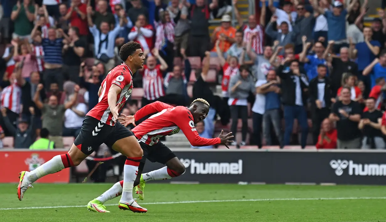 Pemain Southampton Che Adams (kiri) melakukan selebrasi setelah tendangannya dibelokkan pemain Manchester United Fred sehingga menghasilkan gol bunuh diri pada pertandingan Liga Inggris di Stadion St Mary, Southampton, Inggris, 22 Agustus 2021. Pertandingan berakhir imbang 1-1. (Glyn KIRK/AFP)