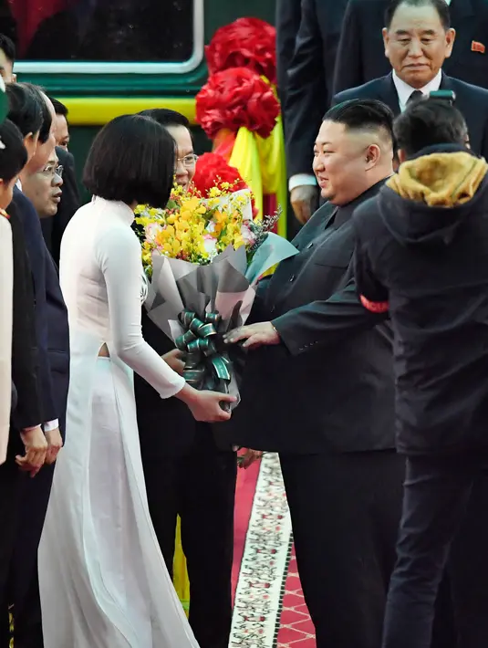 Pemimpin Korea Utara, Kim Jong-un mendapat buket bunga setibanya di Stasiun Dong Dang di Lang Son, Selasa (26/2). Sejumlah pejabat tinggi Vietnam menyambut Kim dengan menggelar karpet merah dan sambutan kenegaraan. (Minoru Iwasaki/Kyodo News via AP)