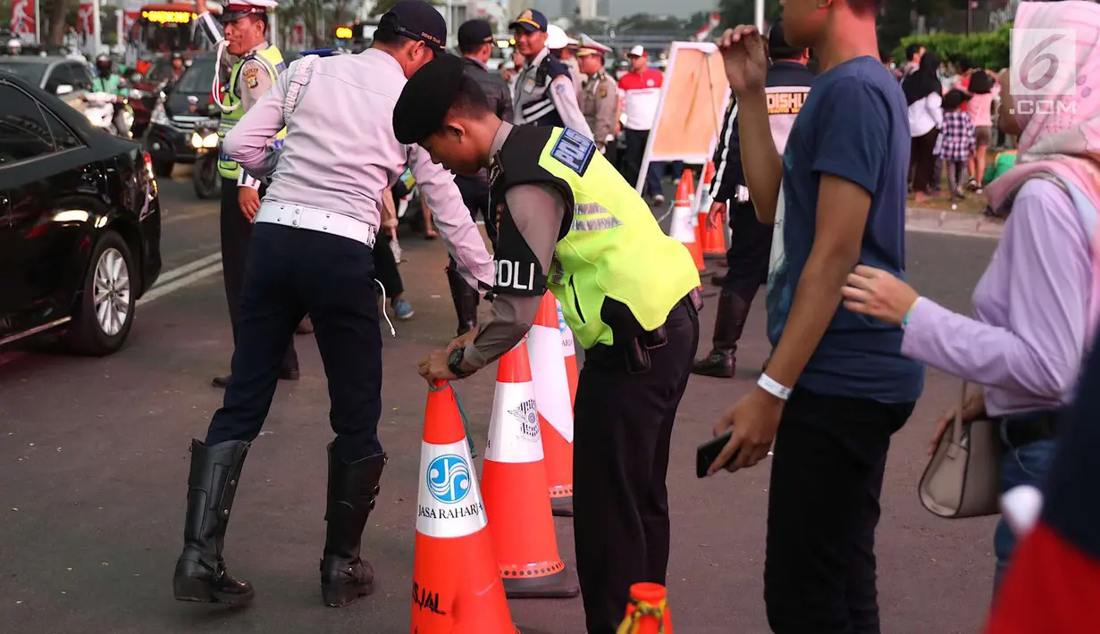 Polisi dan Dishub mengatur lalu lintas di Senayan, Jakarta, Minggu (2/9). Untuk meminimalisasi kemacetan jelang penutupan Asian Games 2018, rekayasa lalu lintas dilakukan di sejumlah ruas jalan dari dan menuji Senayan. (Liputan6.com/Immanuel Antonius)