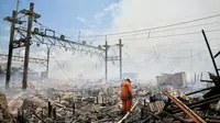 Petugas pemadam kebakaran berusaha mematikan sisa titik api yang masih menyala pemukiman warga di Kampung Bandan, Ancol, Jakarta, Selasa (26/1). Api dengan cepat menjalar rumah warga yang terbuat dari kayu atau bedeng. (Liputan6.com/Faizal Fanani)