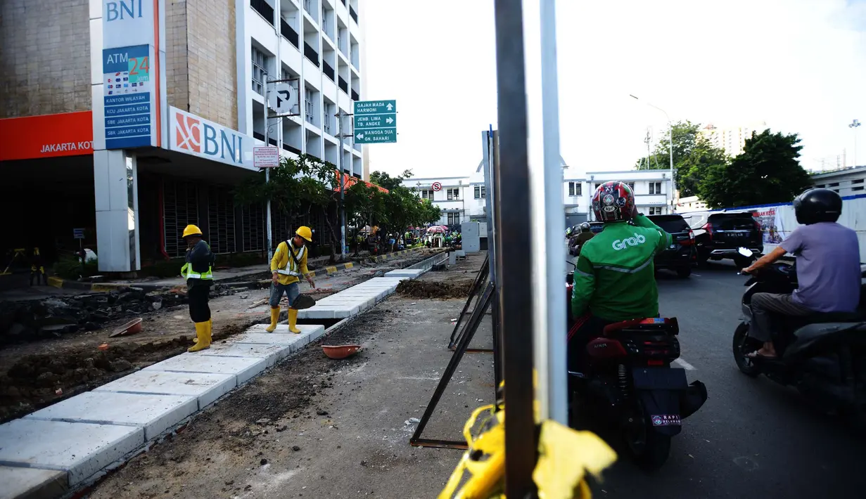 Pekerja menyeselasikan proyek revitalisasi kawasan Kota Tua, Jakarta, Rabu (23/3/2022). Revitalisasi pedestrian ini nantinya akan menjadi plaza pedestrian yang lebar sebagai bentuk penataan kawasan Kota Tua yang rendah emisi dan destinasi pariwisata bersejarah. (merdeka.com/Imam Buhori)