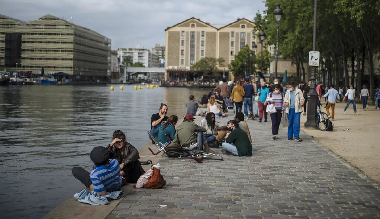 Orang-orang bersantai di Bassin de la Villette Canal, Paris, Prancis, Sabtu (5/6/2021). Jumlah kasus baru COVID-19 di Prancis semakin menurun. (AP Photo/Lewis Joly)