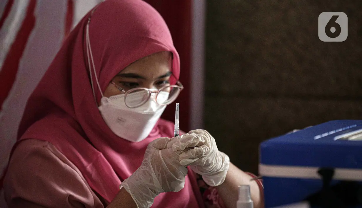 Petugas kesehatan menyiapkan vaksin booster COVID-19 di Pasar Tanah Abang Blok A, Jakarta, Senin (4/4/2022). Vaksinasi yang diselenggarakan Polri ini diikuti warga sekitar dan pedagang Pasar Tanah Abang yang berencana mudik Lebaran. (Liputan6.com/Faizal Fanani)