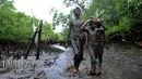 Sejumlah anak berjalan berlumur lumpur saat mengikuti tradisi Mebuug-buugan atau mandi lumpur di desa Kedonganan, Denpasar, Bali (10/3). Mebuug-buugan diadakan sehari usai hari raya Nyepi. (AFP/Sonny Tumbelaka)