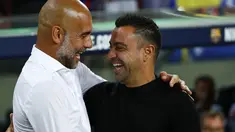 Pelatih Barcelona Xavi Hernandez menyapa manajer Manchester City, Pep Guardiola pada sebuah laga amal di Stadion Camp Nou, Kamis (25/8/2022) dinihari WIB. Laga ini berlangsung menarik karena mempertemukan sang guru dan murid yaitu Pep Guardiola selaku pelatih Man City dan Xavi Hernandes pelatih Barcelona. (AP Photo/Joan Monfort)