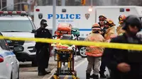 Polisi dan petugas tanggap darurat berkumpul di lokasi penembakan di stasiun kereta bawah tanah Brooklyn, New York, Selasa (12/4/2022). (AFP)