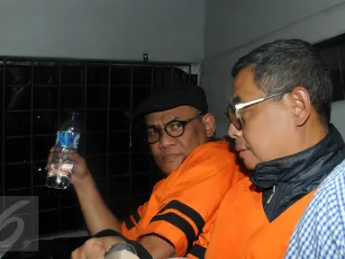 Tersangka pemberi suap terkait rencana proyek pembangunan 12 ruas jalan di Sumatera Barat, Yogan Askan (kiri) selaku pengusaha berada di mobil tahanan usai menjalani pemeriksaan di Gedung KPK, Jakarta, Kamis (30/6).(Liputan6.com/Helmi Afandi)