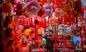Seorang pembeli memotret dekorasi Tahun Baru Imlek di sebuah pasar di Beijing, China, Rabu 4 Februari 2026. Imlek merupakan sebuah perayaan yang sangat penting bagi masyarakat China. Perayaan tahun baru ini didasarkan oleh penanggalan lunar (bulan). (AP Photo/Vincent Thian)