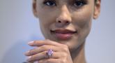 Seorang model mengenakan berlian merah muda cerah 10,57 karat, dengan perkiraan nilai lebih dari $35 juta dolar AS (lebih dari Rp 526 miliar), selama pratinjau pers di Sotheby's di New York City pada 27 Maret 2023. (Photo by ANGELA WEISS / AFP)
