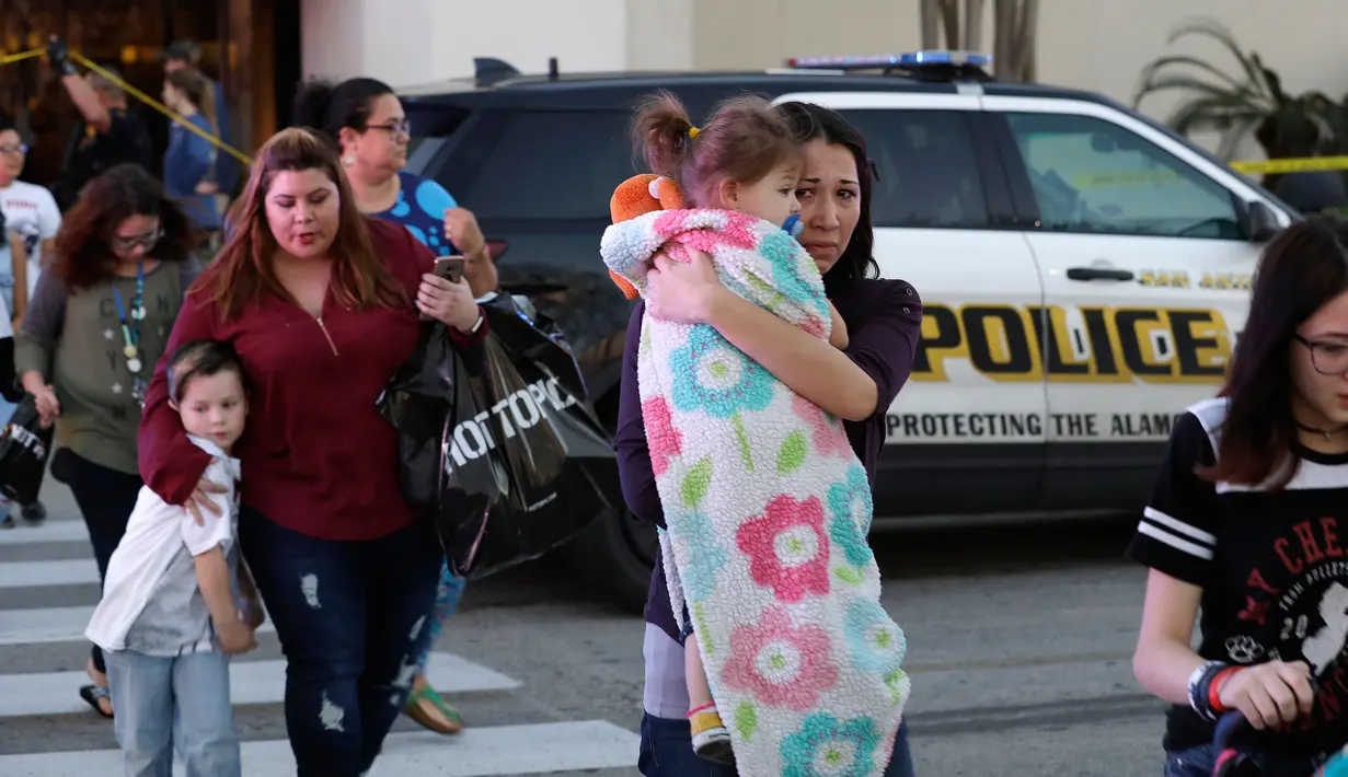 Pengunjung berjalan keluar setelah terjadinya baku tembak di Rolling Oaks Mall, San Antonio, Texas, Minggu (22/1). Penembakan ini tercatat untuk pertama kalinya setelah Presiden Donald Trump dilantik sebagai Presiden AS. (AP Photo/Eric Gay)