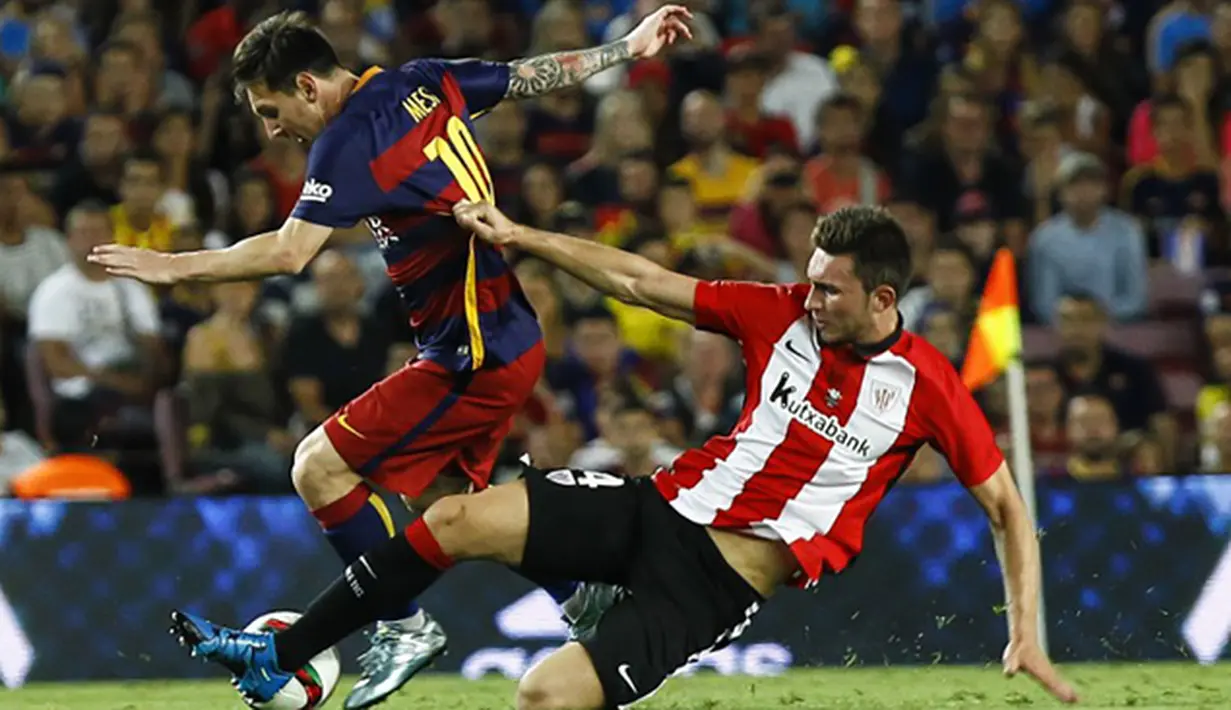 Penyerang Barcelona, Lionel Messi menghindari hadangan pemain Athletic Bilbao, Aymeric Laporte pada laga Piala Super Spanyol di Stadion Camp Nou, Spanyol, Senin (17/8/2015). (AFP Photo/Quique Garcia)