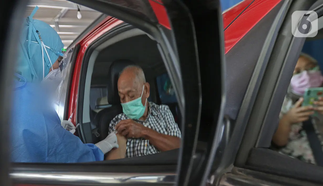 Warga lanjut usia (lansia) mendapatkan vaksinasi Covid-19 secara drive-thru di area parkir Hall C JIExpo Kemayoran, Jakarta, Rabu (3/3/2021). Kementerian Kesehatan berkolaborasi bersama sejumlah mitra dalam layanan vaksinasi drive thru tersebut. (Liputan6.com/Herman Zakharia)