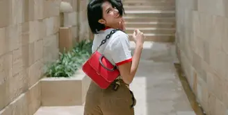 Aghniny Haque berperan sebagai Ayu dalam film KKN di Desa Penari. Aghniny dikenal dengan gaya khasnya yang boyish dengan rambut pendek. Di sini terlihat ia mengenakan t-shirt putih, dipadu dengan celana panjang berwarna cokelat, dan ia menenteng tas berwarna merah. Foto: Instagram.