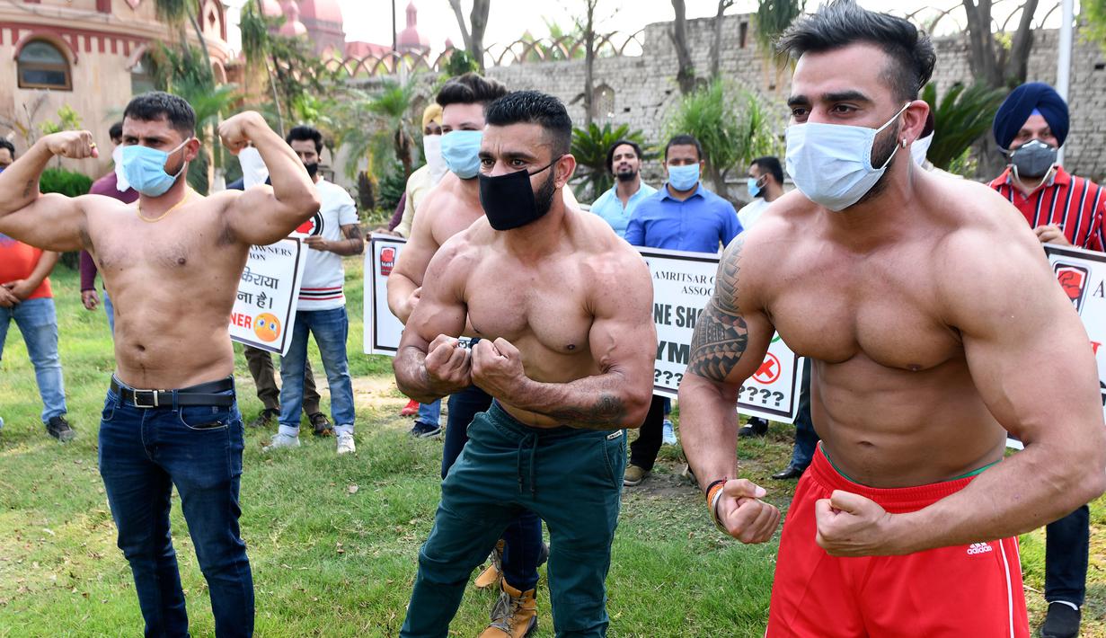 Pemilik dan pelatih gym memamerkan otot mereka saat protes menuntut pemerintah membuka kembali pusat kebugaran di Amritsar, India, Minggu (7/6/2020). Mereka meminta aktivitas tempat olahraga gym juga diizinkan buka setelah pelonggaran lockdown, bukan hanya kegiatan perekonomian. (NARINDER NANU/AFP)