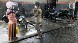 Karyawan penyandang tunarungu berkomunikasi menggunakan bahasa isyarat dengan pelanggannya di Deaf Cafe and Car Wash di kawasan Cinere, Depok, Jawa Barat, Senin (27/9/2021). Seluruh karyawan di tempat cuci mobil-motor dan kafe ini merupakan penyandang tunarungu. (merdeka.com/Arie Basuki)