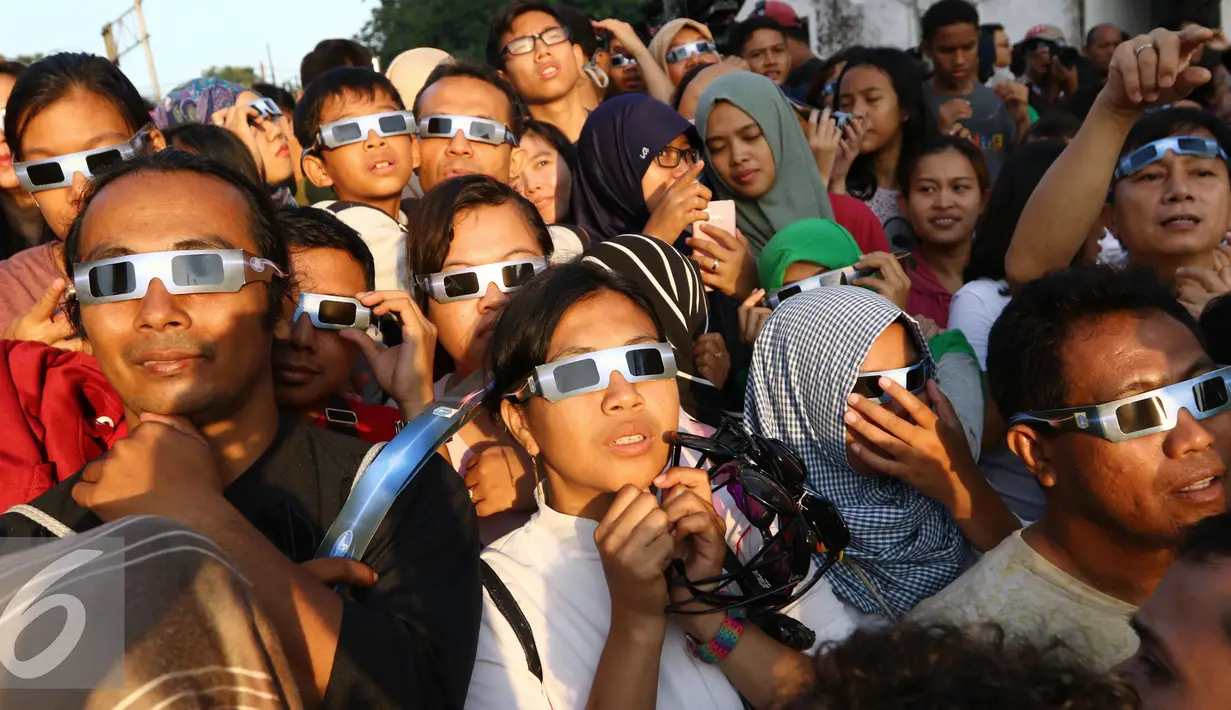 Sejumlah warga menyaksikan proses Gerhana Matahari Total (GMT) 2016 di halaman Taman Ismail Marzuki (TIM), Jakarta, Rabu (9/3). Fenomena gerhana matahari 90% bisa diamati selama 2,11 menit. (Liputan6.com/Fery Pradolo)