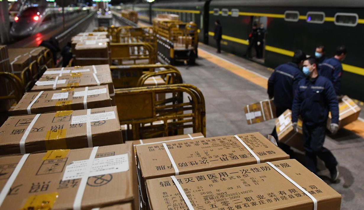 Para staf memuat sejumlah baju pelindung di Stasiun Kereta Barat Beijing di Beijing, ibu kota China (4/3/2020). Total 20.000 baju pelindung disalurkan ke Wuhan guna membantu upaya kota itu memerangi wabah coronavirus baru. (Xinhua/Zhang Chenlin)