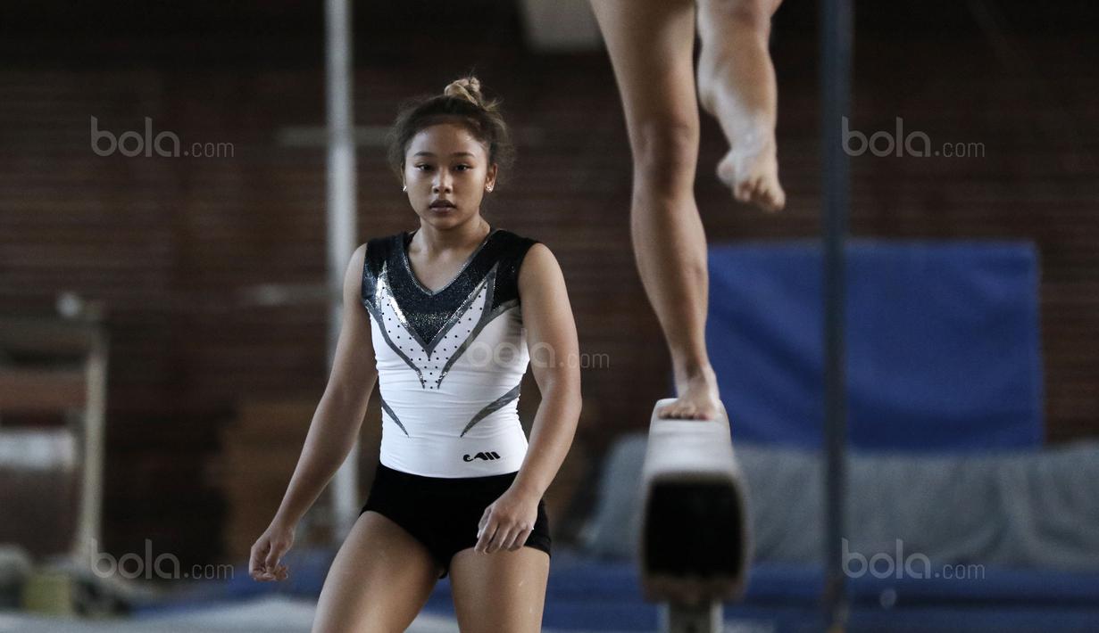 Rifda (kiri) menyaksikan aksi Tia diatas palang saat latihan persiapan SEA Games 2017 di GOR Senam Radin Inten, Jakarta Timur, Rabu (09/8/2017). SEA Games 2017 dimulai 19-30 Agustus di Malaysia. (Bola.com/Nicklas Hanoatubun)