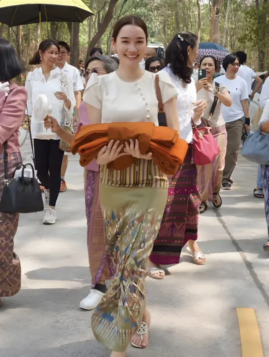 Diana mengenakan atasan putih serta kain berwarna hijau bermotif abstrak dipadukan sandalnya.  (@dianaflipo)