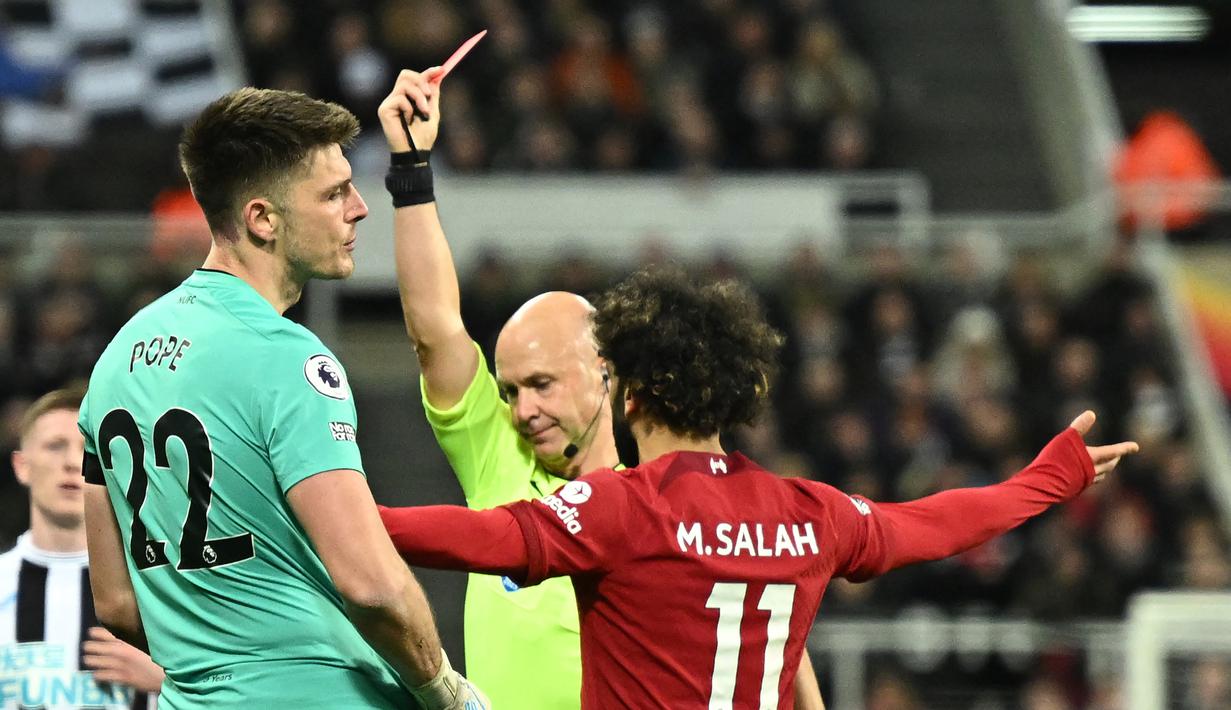 Nick Pope. Kiper Newcastle United, Nick Pope (kiri) mendapat kartu merah dari wasit Anthony Taylor saat menghadapi Liverpool pada laga pekan ke-24 Liga Inggris 2022/2023 di St James' Park, Newcastle (18/2/2023). Kartu merah diterima akibat menjangkau bola di luar kotak penalti saat berusaha meredam aksi Mohamed Salah pada menit ke-22. Ia diskors dalam dua laga, termasuk absen saat laga final Piala Liga kontra Manchester United (26/2/2023). (AFP/Oli Scarff)