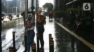 Warga melintasi jalan saat hujan di kawasan Bundaran Hotel Indonesia, Jakarta, Senin (1/11/2021). BMKG mengeluarkan peringatan dini cuaca ekstrem berupa hujan dengan intensitas sedang hingga lebat untuk berbagai wilayah di Indonesia hingga 6 November 2021. (Liputan6.com/Faizal Fanani)