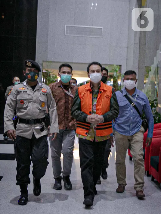 Wakil Ketua DPR Aziz Syamsuddin digiring petugas menuju mobil tahanan di Gedung KPK Jakarta, Sabtu (25/9/2021). Politisi Partai Golkar ini ditetapkan sebagai tersangka dan langsung ditahan KPK terkait kasus penanganan perkara di Kabupaten Lampung Tengah. (Liputan6.com/Faizal Fana