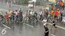 Hujan mengguyur kawasan Bundaran HI saat kegiatan Car Free Day di Jakarta, Minggu (24/1/2016). Sejumlah pengunjung tetap melaksanakan olahraga di bawah guyuran hujan. (Liputan6.com/Helmi Affandi)