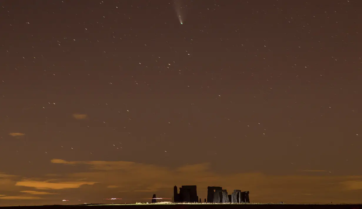 Foto yang diabadikan pada 23 Juli 2020 ini memperlihatkan Komet Neowise di atas monumen Stonehenge di Wiltshire, Inggris. Fenomena ini cukup langka karena membutuhkan waktu 6.800 tahun lagi untuk dapat kembali mendekati orbit Bumi. (Xinhua/Tim Ireland)
