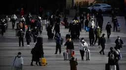 Suasana saat para pemudik yang memakai masker berjalan menuju pintu masuk Stasiun Kereta Api Beijing di Beijing, China, Sabtu (14/1/2023). Jutaan warga China diperkirakan akan melakukan perjalanan selama periode liburan Tahun Baru Imlek tahun ini. (AP Photo/Mark Schiefelbein)