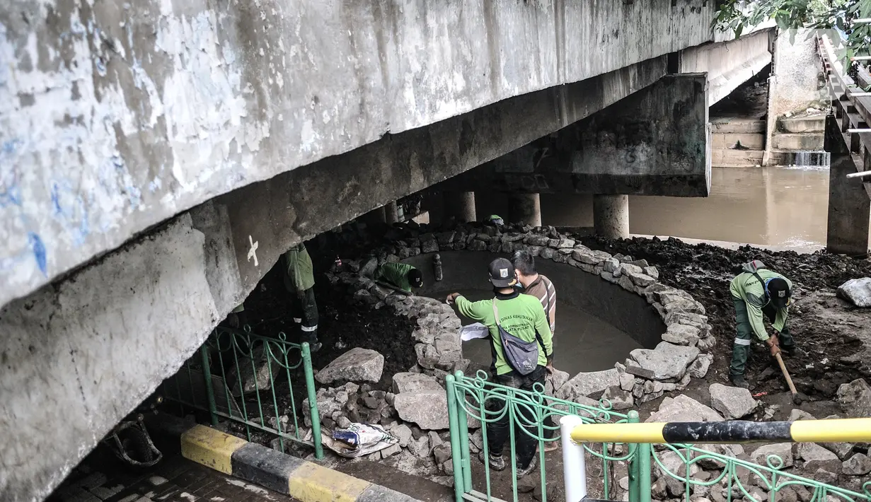 Petugas Suku Dinas Pertamanan Jakarta Pusat menyelesaikan pembangunan taman di kolong Jembatan Pegangsaan, Jakarta, Selasa (19/1/2021). Selain menjadi area interaksi warga sekitar, pembangunan taman di kolong jembatan tersebut untuk mempercantik kawasan bantaran kali. (merdeka.com/Iqbal S. Nugroho)