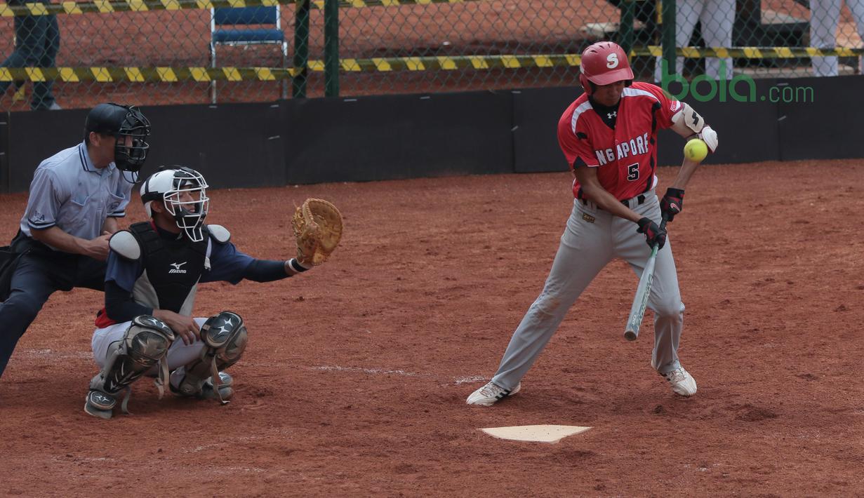 Pemain Singapura, F.Harahap memukul bola mengecoh pemain Taiwan pada laga Asian Softball Championship di Senayan, Jakarta,Selasa (24/4/2018). Singapura menang 12-4. (Bola.com/Nick Hanoatubun)