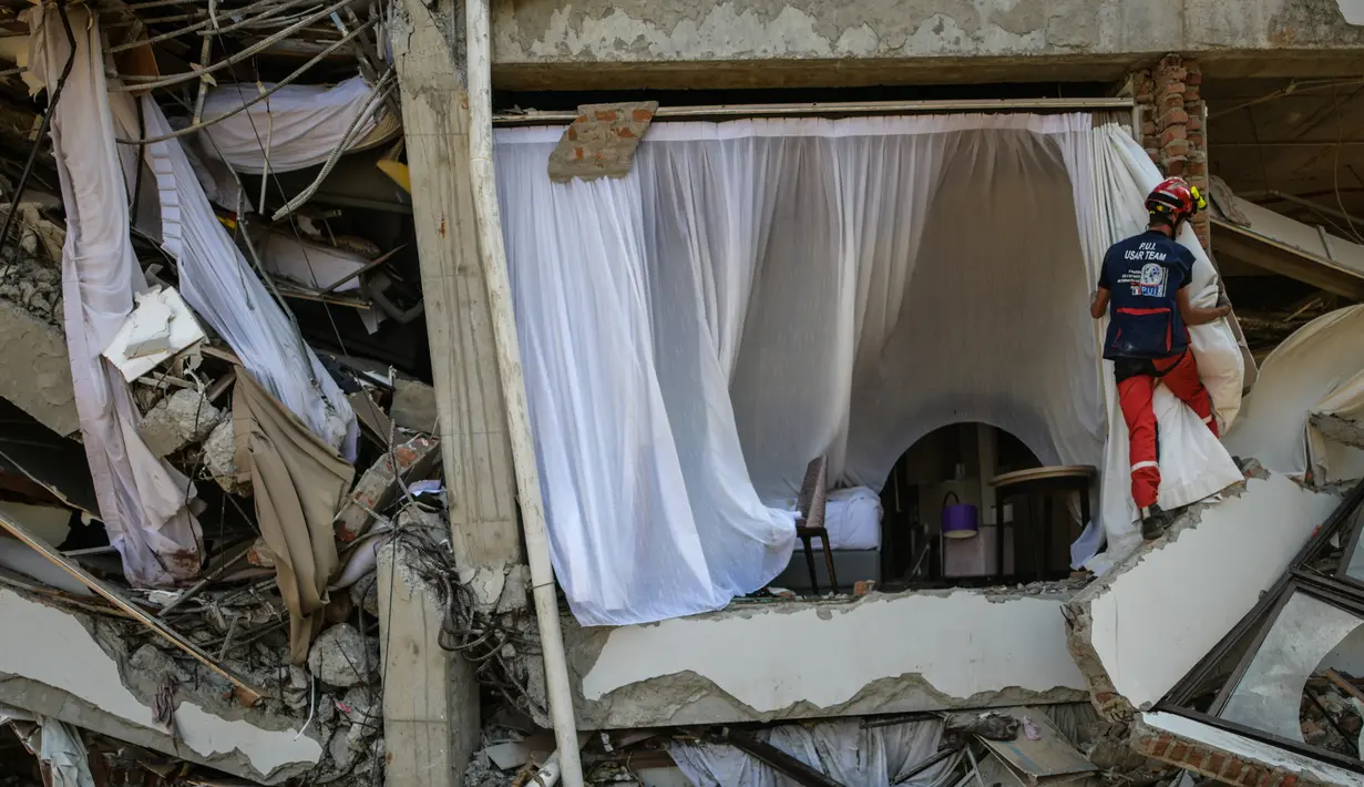 Anggota dari Pemadam Kebakaran Darurat Internasional Prancis mencari korban gempa dan tsunami di Palu, Sulteng (4/10). Lebih dari 2.500 terluka setelah gempa besar pada 28 September di daerah tersebut. (AFP Photo/Mohd Rasfan)