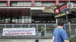 Warga melintas di depan Plaza Kenari Mas yang tutup, Jakarta, Rabu (7/7/2021). Pusat elektronik tersebut ditutup sejak 6 Juli hingga 20 Juli atau sampai berakhirnya masa PPKM Darurat. (merdeka.com/Iqbal S. Nugroho)