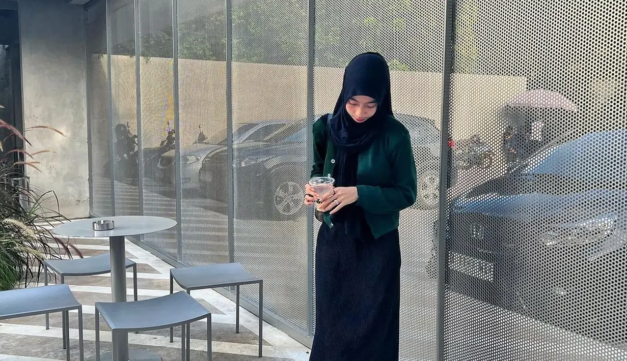 Inspirasi outfit ke cafe yang minimalis. Adiba memadukan knit dress hitamnya dengan knit cardigan hijau dan sneakers.  [Instagram/adiba.knza]