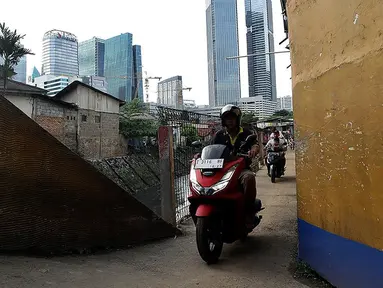 Pengendara sepeda motor melintasi jalur alternatif di belakang Kompleks Patra Jasa, Jakarta Selatan, Rabu (1/3/2023). (Liputan6.com/Johan Tallo)