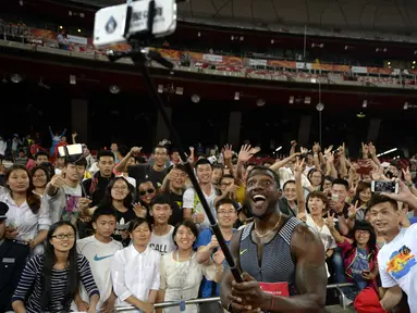 Pelari asal Amerika Serikat, Justin Gatlin berfoto selfie bersama ratusan fans usai lari menjuarai 100m putra pada kejuaraan IAAF World Challenge di National Olympic Stadium atau 'Birds Nest', Beijing, (18/5/2016). (AFP/Wang Zhao)