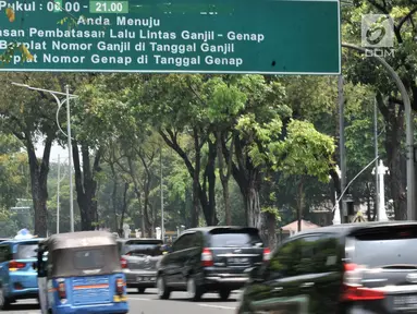 Kendaraan melintas di bawah rambu pemberitahuan sistem ganjil genap di Jalan Medan Merdeka Utara, Jakarta, Senin (3/9). Pemprov DKI Jakarta melalui Pergub Nomor 92 Tahun 2018 memperpanjang waktu sistem ganjil genap. (Merdeka.com/Iqbal S. Nugroho)