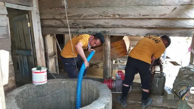 Tim Manggala Agni Sultra, menyedot sumur warga desa usai banjir, Rabu (19/6/2019).(Liputan6.com/Ahmad Akbar Fua)
