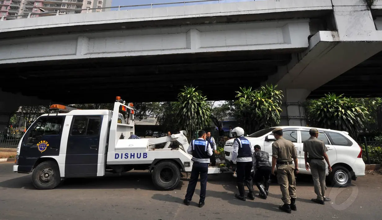 Untuk membuat jera, Pemprov DKI menerapkan operasi derek bagi mobil-mobil yang diparkir secara liar, Jakarta, Rabu (12/11/2014). (Liputan6.com/Miftahul Hayat)