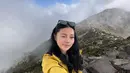 Gaya kece Wendy dengan jaket parka kuning dan celana cargo saat berhasil taklukan puncak gunung Arjuno.  [Instagram/wendywalters]