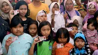 Anak-anak memperlihatkan Kartu Identitas Anak (KIA) di tempat makan siap saji kawasan Bintaro Tangerang Selatan, Selasa (26/2). Pemkot Tangsel menargetkan sebelum tahun ajaran baru 2019/2020 semua anak Tangsel sudah memiliki KIA. (Merdeka.com/Arie Basuki)