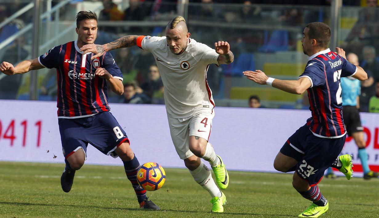 Pemain Roma, Radja Nainggolan (tengah) mencoba melewati hadangan dua pemain  Crotone pada lanjutan Serie A di Ezio Scida stadium, Crotone, Italy (12/2/2017).  AS Roma menang 2-0.  (AFP/Carlo Hermann)