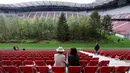 Pengunjung melihat instalasi ekosistem hutan di Stadion Woerthersee, Austria, Minggu (8/9/2019). Tempat itu kini lebih mirip seperti hutan yang telah ditumbuhi pepohonan di area lapangan dibanding tempat untuk bertanding sepak bola. (AP/Ronald Zak)