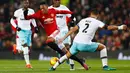 Penyerang MU, Anthony Martial (tengah) berusaha melewati bek West Ham United, Winston Reid di perempat final Piala Liga (EFL Cup) di Stadion Old Trafford, Inggris, (1/12). MU menang telak atas West Ham dengan skor 4-1. (Reuters/Jason Cairnduff)